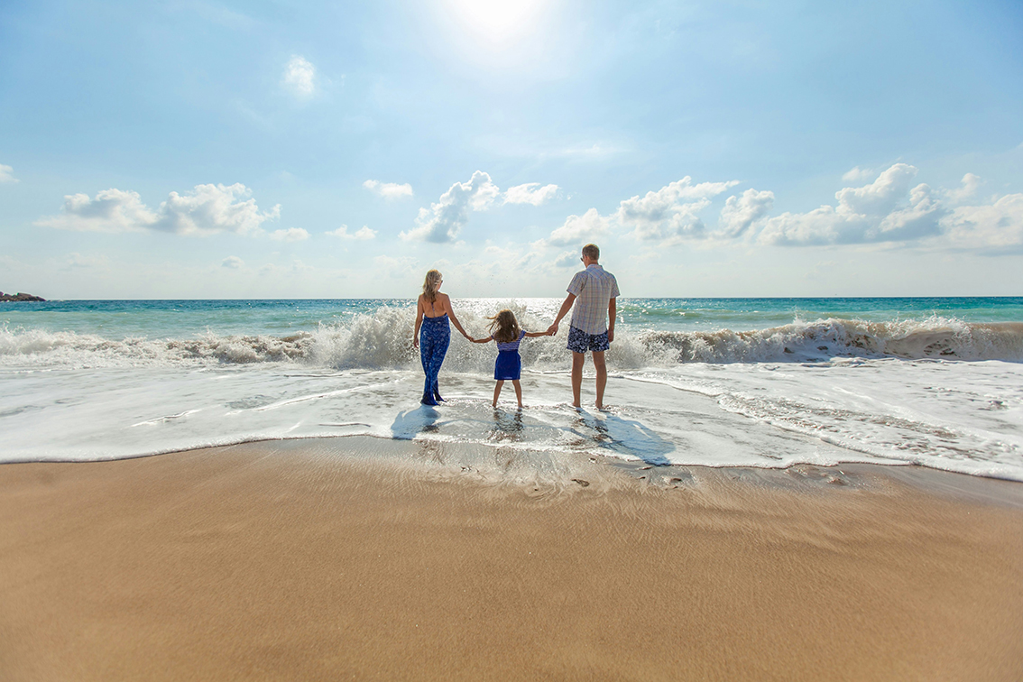 Image of family holding hands at the beach